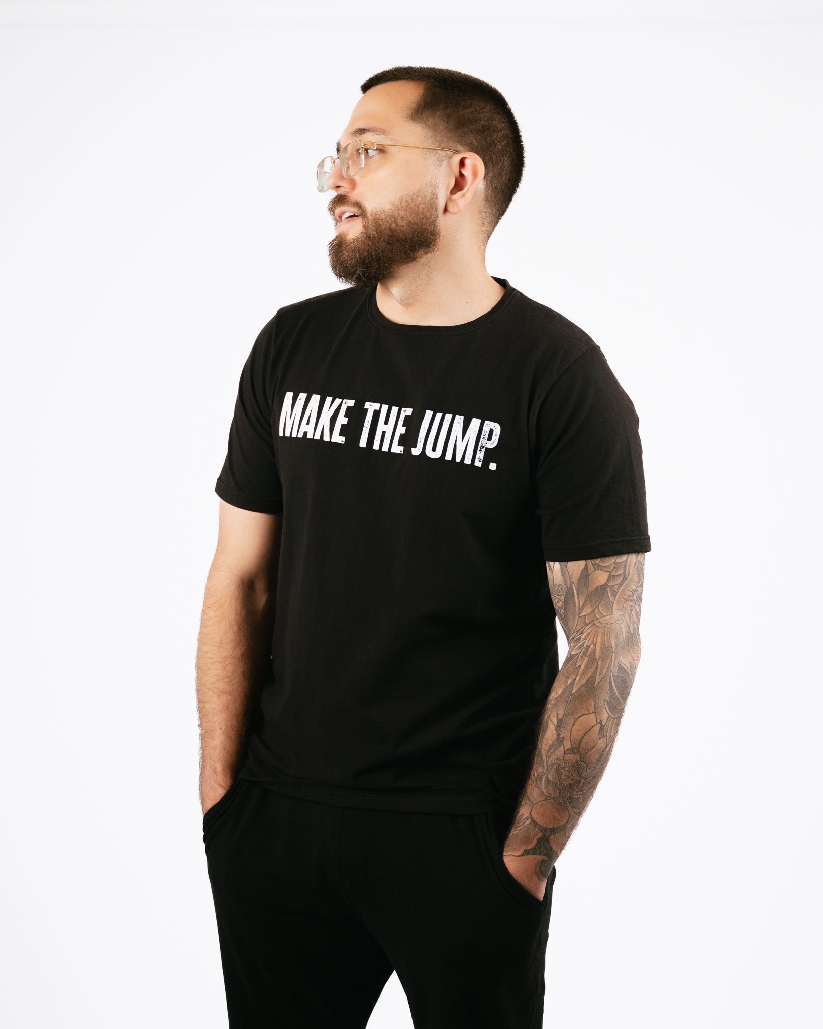 Man wearing a black t-shirt with 'MAKE THE JUMP.' text on a white background