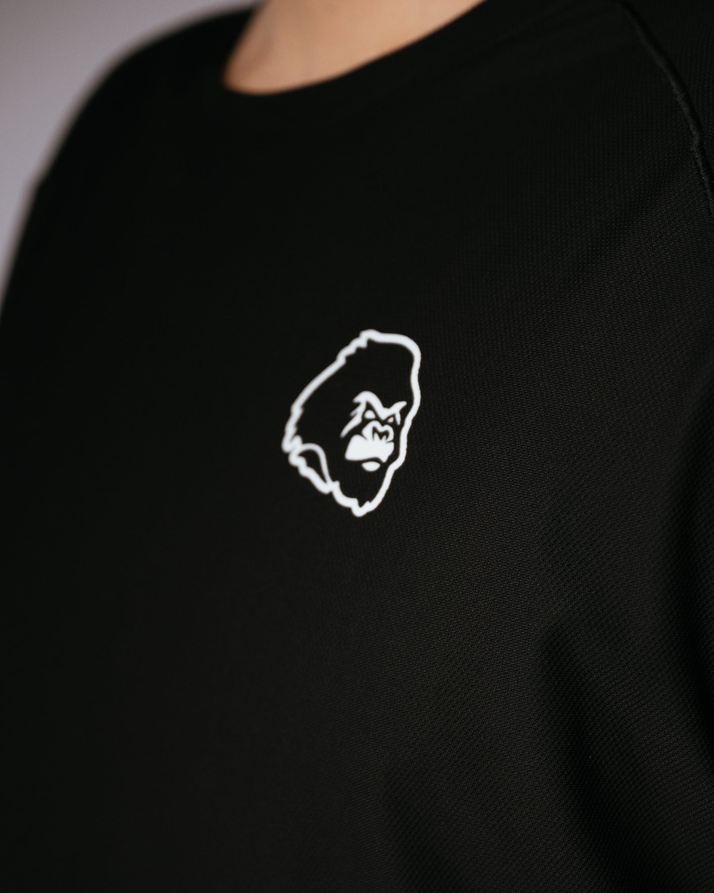 Black shirt with a white gorilla logo on the chest.