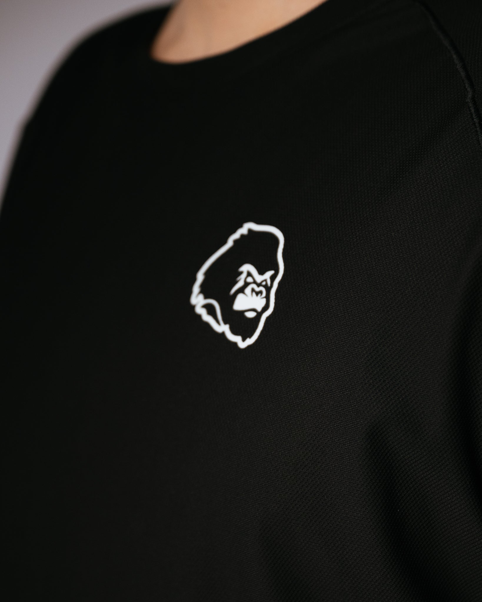 Black shirt with a white gorilla logo on the chest.